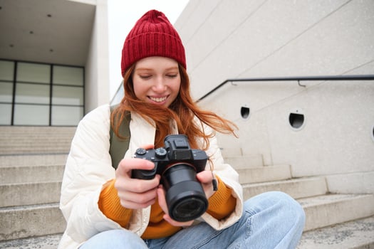Urban people and lifestyle. Happy redhead woman takes photos, holding professional digital camera, photographing on streets photo