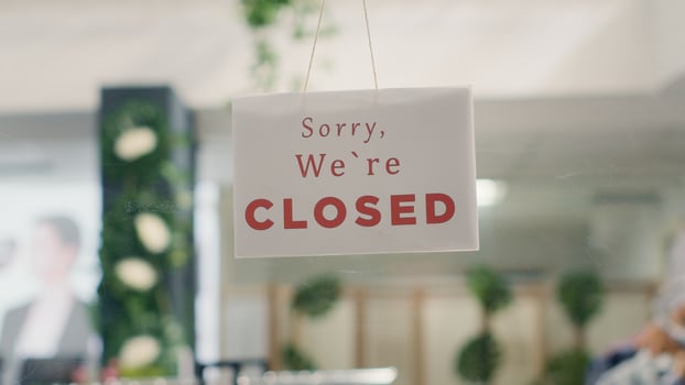Sorry we are closed sign in empty clothing store in mall with fast fashion clothes following the latest trends. Message on fashion boutique door announcing customers that shop is closed photo