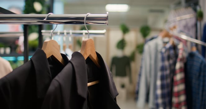 Camera viewpoint travelling through stylish selection of shirts on hangers in high end designer showroom showcasing trendy garments from new collection. Mall fashion boutique aisles full of men attire photo