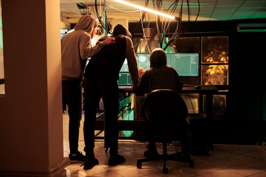 Cyber criminals team hacking database, stealing personal information, hackers running malicious software code. Cyberterrorism, internet thieves in hoodies breaking into server photo