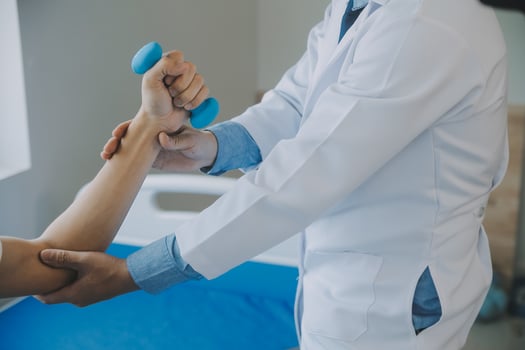 Doctor or physical therapist examines back pain and spinal area to give advice within the rehabilitation center. photo