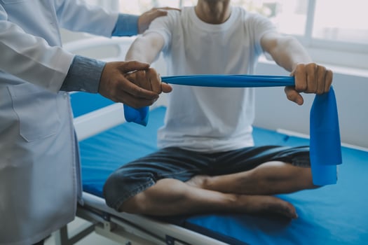 Doctor or physical therapist examines back pain and spinal area to give advice within the rehabilitation center. photo