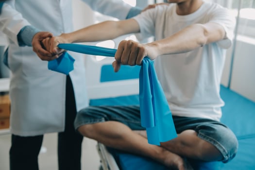 Doctor or physical therapist examines back pain and spinal area to give advice within the rehabilitation center. photo