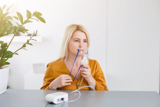 Portrait of adult woman using steam vapor inhaler nebulizer doing aerosol inhalation medicine treatment at home or hospital flu and asthma bronchitis virus healing photo