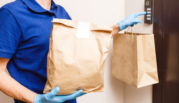 Young man delivering food to customer at doorway photo