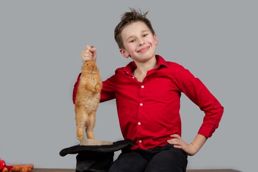 The magician boy takes out the rabbit from the cap. photo