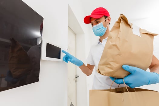 home delivery, online order. A man in uniform, a medical mask and rubber gloves with a box, a parcel in his hands. Food and food delivery during the quarantine of the coronavirus pandemic photo