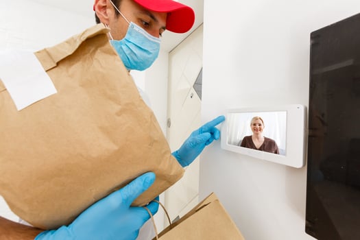 home delivery, online order. A man in uniform, a medical mask and rubber gloves with a box, a parcel in his hands. Food and food delivery during the quarantine of the coronavirus pandemic photo