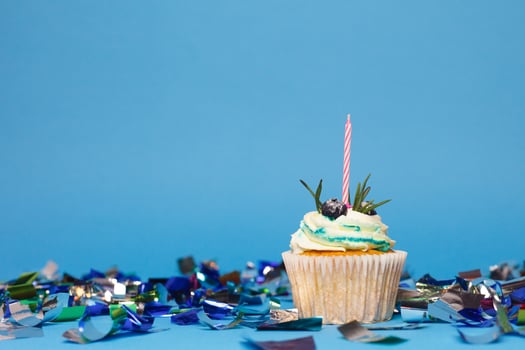 birthday cupcake with three burning candles over blue background photo