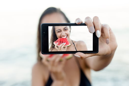 Summer vacation - young girl eating fresh watermelon on sandy beach photo
