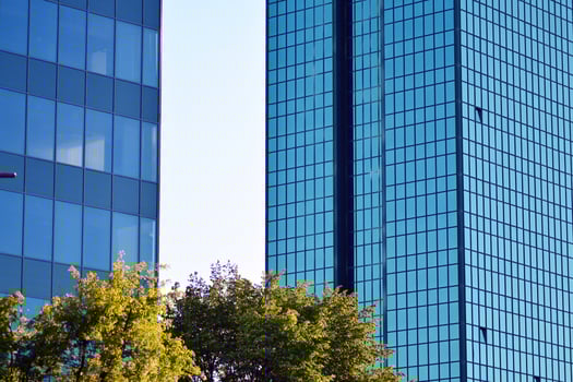 Glass building with transparent facade of the building and blue sky. Structural glass wall reflecting blue sky. Abstract modern architecture fragment. Contemporary architectural background. photo