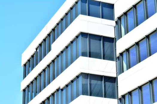 Abstract closeup of the glass-clad facade of a modern building covered in reflective plate glass. Architecture abstract background. Glass wall and facade detail. photo