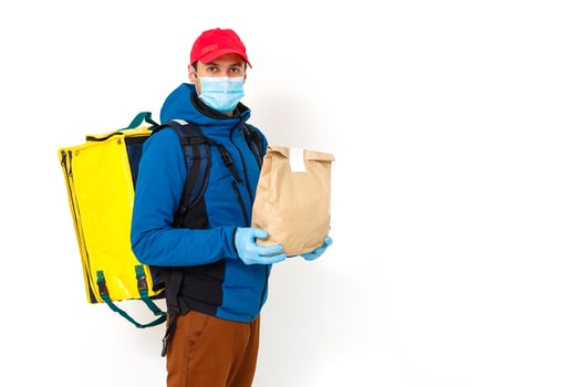 Young courier with thermo bag on white background. Food delivery service photo