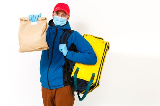 Young courier with thermo bag on white background. Food delivery service photo