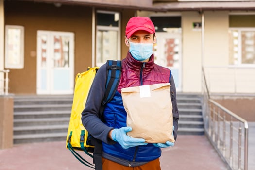 contactless food delivery to customers home. Delivery service worker with thermal backpack quick delivering food at doorstep in quarantine from restaurant, supermarket or cafe . Online ordering food photo