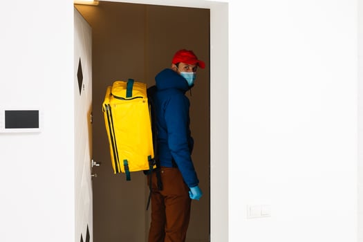 contactless food delivery to customers home. Delivery service worker with thermal backpack quick delivering food at doorstep in quarantine from restaurant, supermarket or cafe . Online ordering food photo