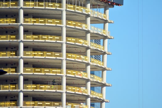 High rise building under construction. Installation of glass facade panels on a reinforced concrete structure. photo