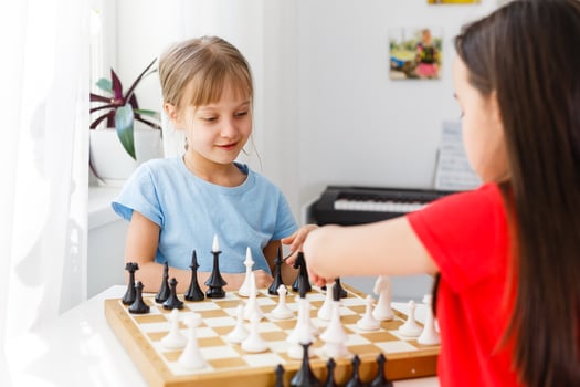 Two cute children playing chess at home photo