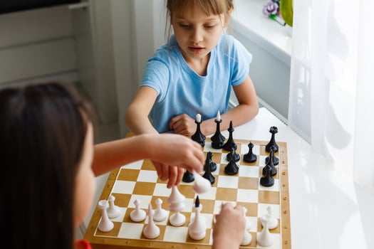 Two cute children playing chess at home photo