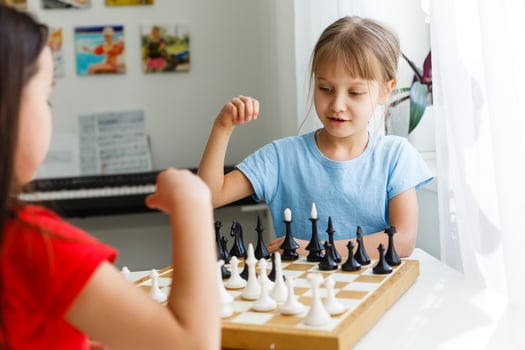 Two little sister playing chess at home photo