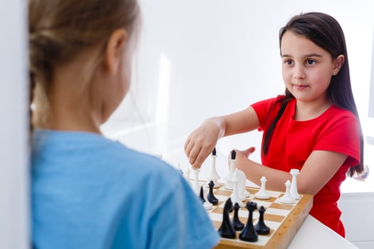 Two cute children playing chess at home photo
