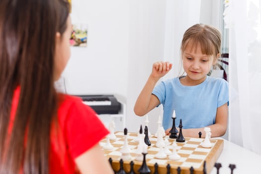 Two cute children playing chess at home photo