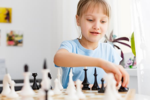 Girl moving a counter while playing chess photo