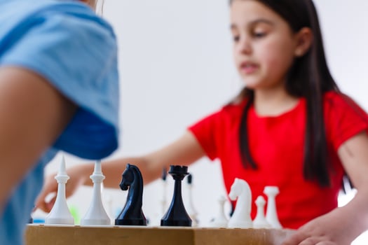 Two cute children playing chess at home photo