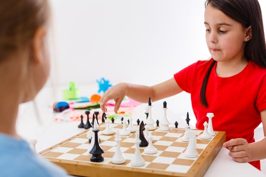 Two little sister playing chess at home photo