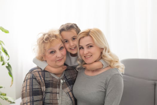 Portrait of three generations of women look at camera posing for family picture, cute little girl hug mom and granny enjoy time at home, smiling mother, daughter and grandmother spend weekend together photo