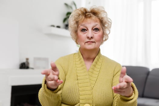 Smiling middle aged mature grey haired woman looking at camera, happy old lady posing at home indoor, positive single senior retired female sitting on sofa in living room headshot portrait photo