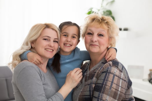 Portrait of three generations of women look at camera posing for family picture, cute little girl hug mom and granny enjoy time at home, smiling mother, daughter and grandmother spend weekend together photo