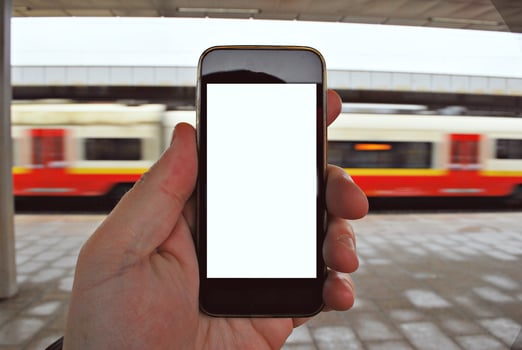 Hand holding smartphone with subway station background photo