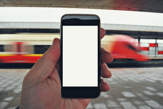 Hand holding smartphone with subway station background photo
