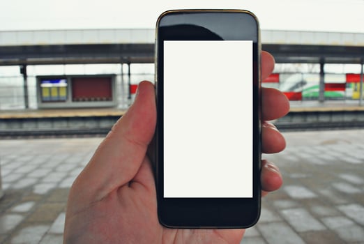 Hand holding smartphone with subway station background photo