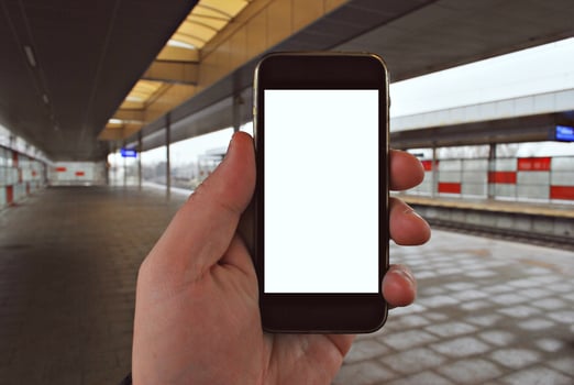 Hand holding smartphone with subway station background photo
