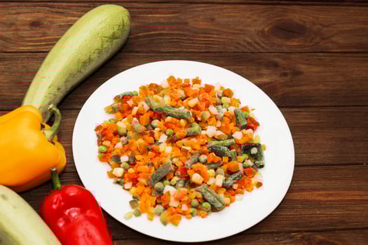 Frozen vegetables carrots, peas, beans in a plate photo
