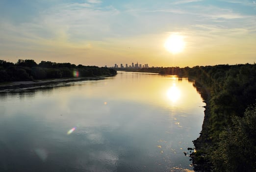 River in the city in at colorful sunset in the background photo