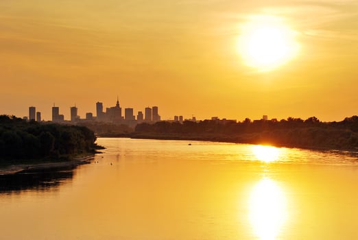 River in the city in at colorful sunset in the background photo