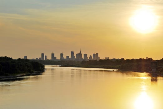 River in the city in at colorful sunset in the background photo
