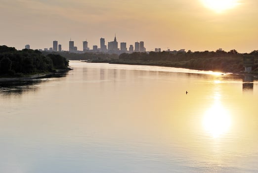 River in the city in at colorful sunset in the background photo