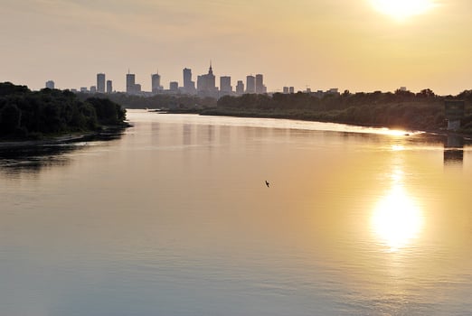 River in the city in at colorful sunset in the background photo