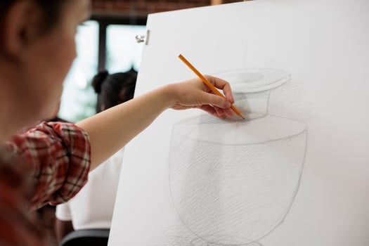Creative process. Female artist sketching and shading vase with pencil, learning to draw and sketch at art school, woman enjoying drawing as hobby attending creative workshop to develop creativity photo