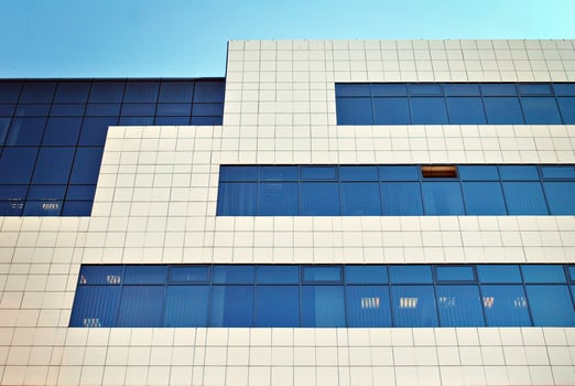 Glass building with transparent facade of the building and blue sky. Structural glass wall reflecting blue sky. Abstract modern architecture fragment. Contemporary architectural background. photo