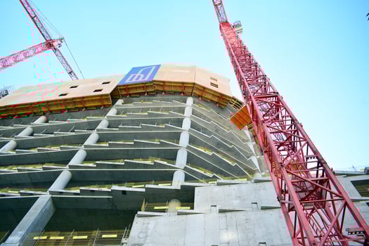 High rise building under construction. Installation of glass facade panels on a reinforced concrete structure. photo