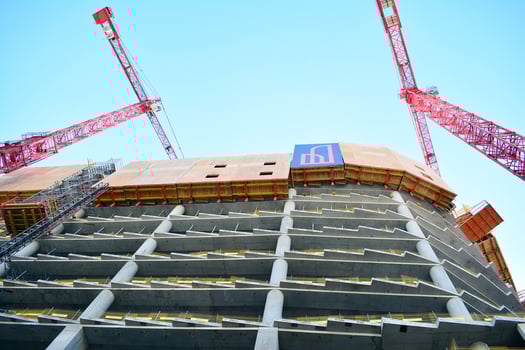High rise building under construction. Installation of glass facade panels on a reinforced concrete structure. photo