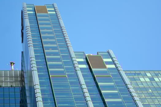 Glass building with transparent facade of the building and blue sky. Structural glass wall reflecting blue sky. Abstract modern architecture fragment. Contemporary architectural background. photo