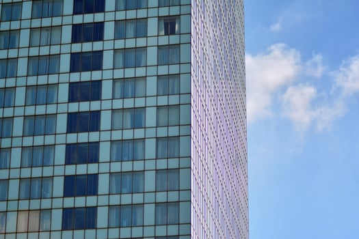 Glass building with transparent facade of the building and blue sky. Structural glass wall reflecting blue sky. Abstract modern architecture fragment. Contemporary architectural background. photo