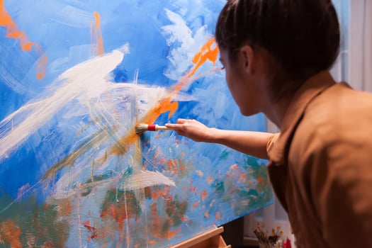 Woman working on details on large canvas in art studio. Modern artwork paint on canvas, creative, contemporary and successful fine art artist drawing masterpiece photo