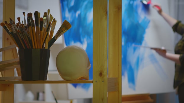 Young female artist in her studio painting a masterpiece. photo